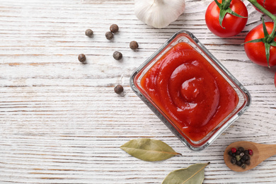 Photo of Flat lay composition with tomato sauce on white wooden table, space for text