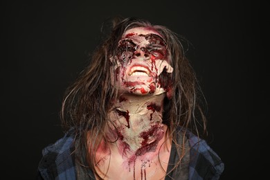 Photo of Scary zombie on dark background. Halloween monster