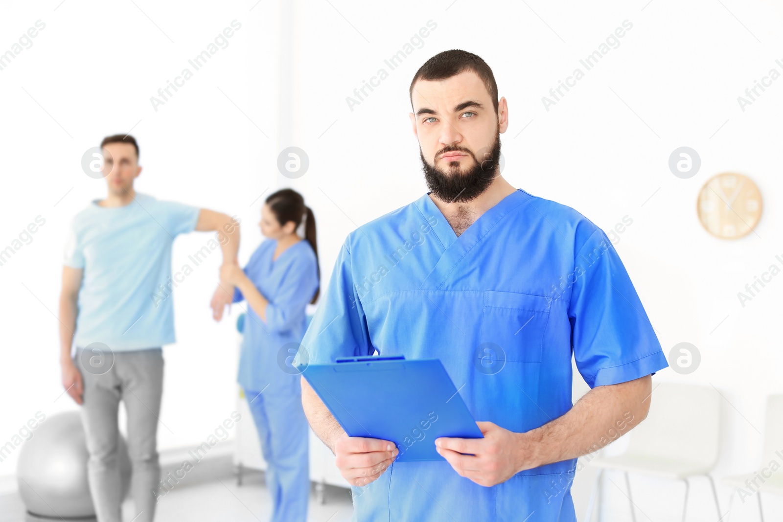 Photo of Young physiotherapist with clipboard in rehabilitation center