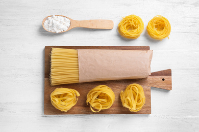 Photo of Flat lay composition with different types of pasta on white wooden table
