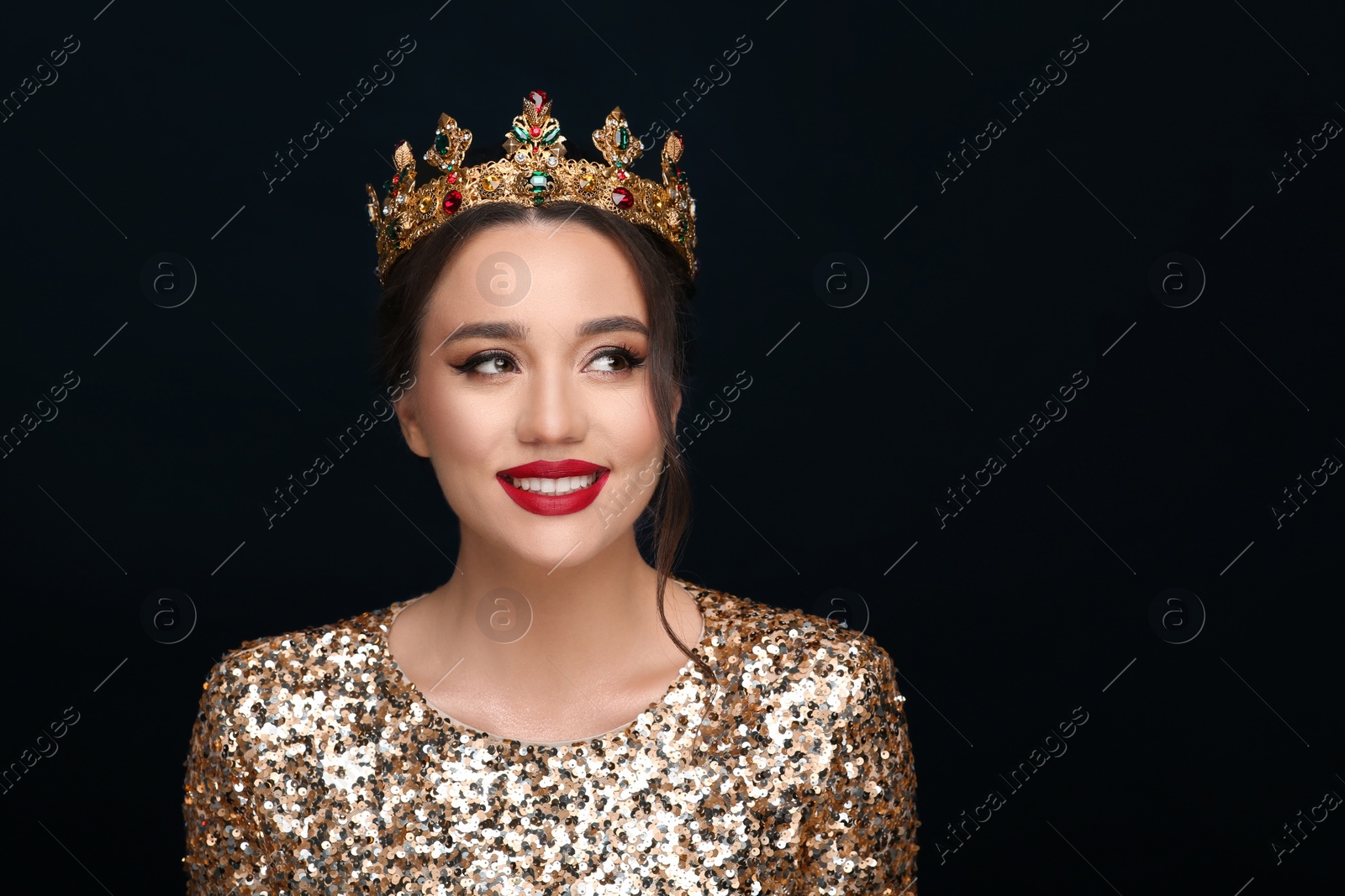 Photo of Beautiful young woman wearing luxurious crown on black background, space for text