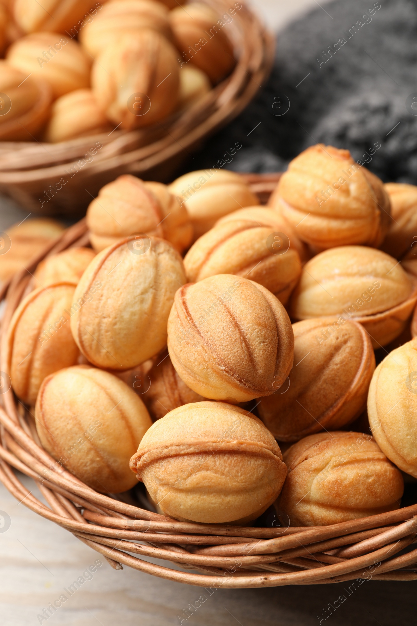Photo of Bowls of delicious nut shaped cookies on white wooden table, closeup