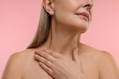 Photo of Mature woman with healthy skin on pink background, closeup