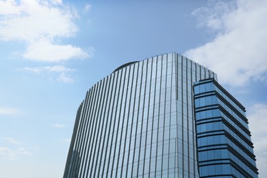 Low angle view of modern building with many windows against blue sky