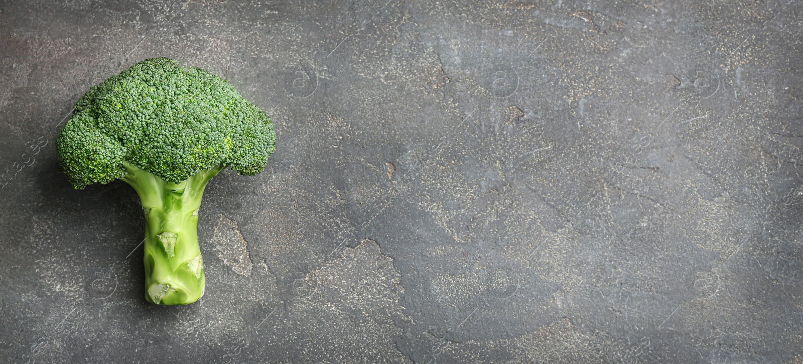 Image of Top view of fresh green broccoli on dark marble table, space for text. Banner design 