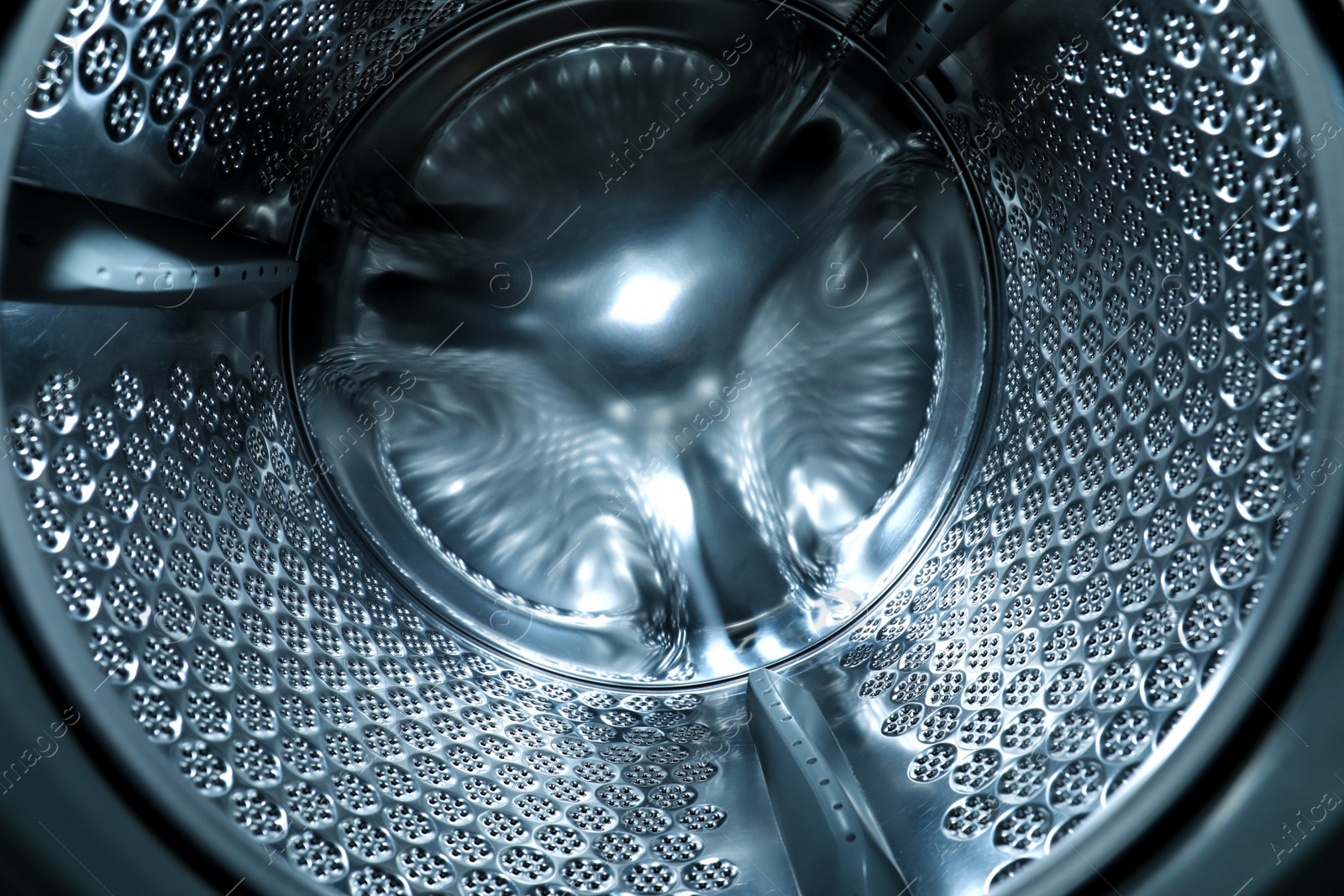 Photo of Empty washing machine drum, closeup. Laundry day