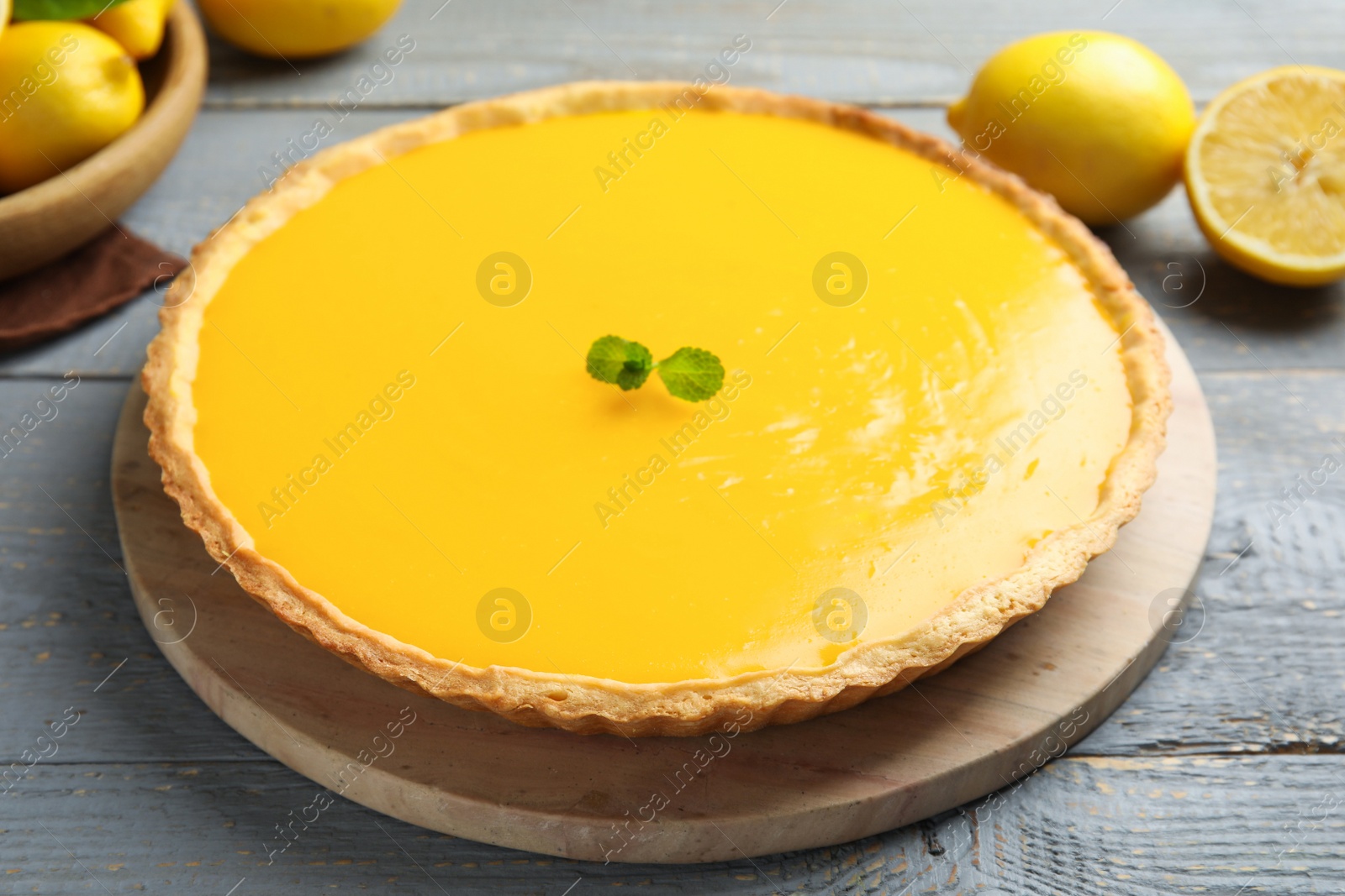 Photo of Delicious homemade lemon pie with mint on wooden table