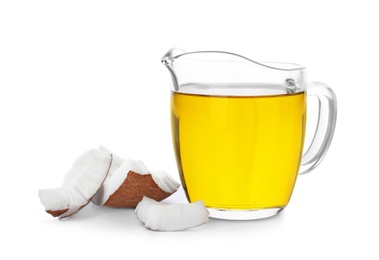 Ripe coconut and oil in pitcher on white background. Healthy cooking