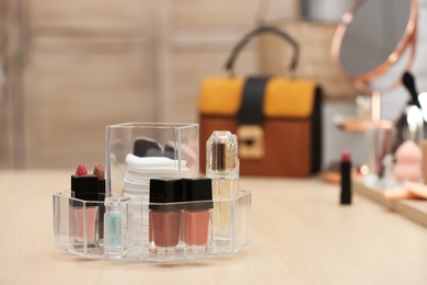 Organizer with cosmetic products and makeup accessories on dressing table. Space for text