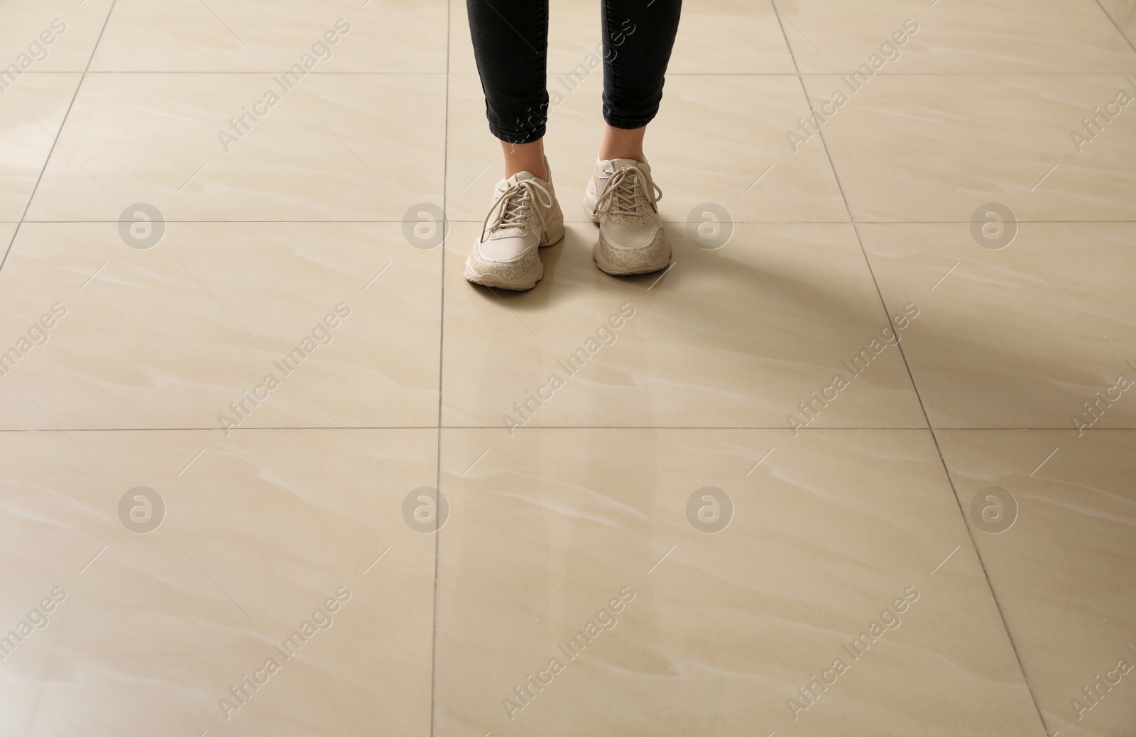 Photo of Woman standing on ceramic floor, closeup. Space for text