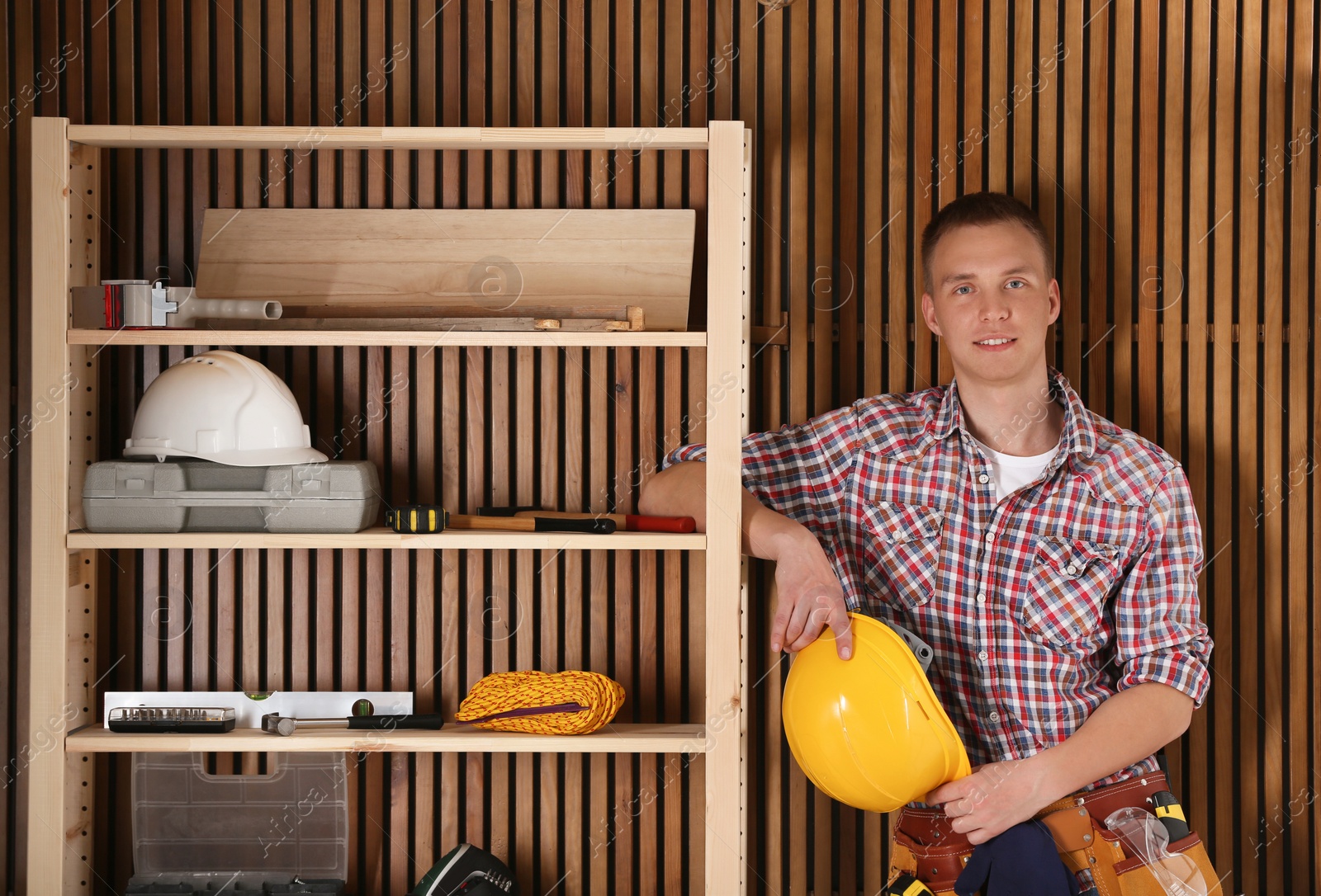 Photo of Handsome young working man with hard hat indoors. Home repair