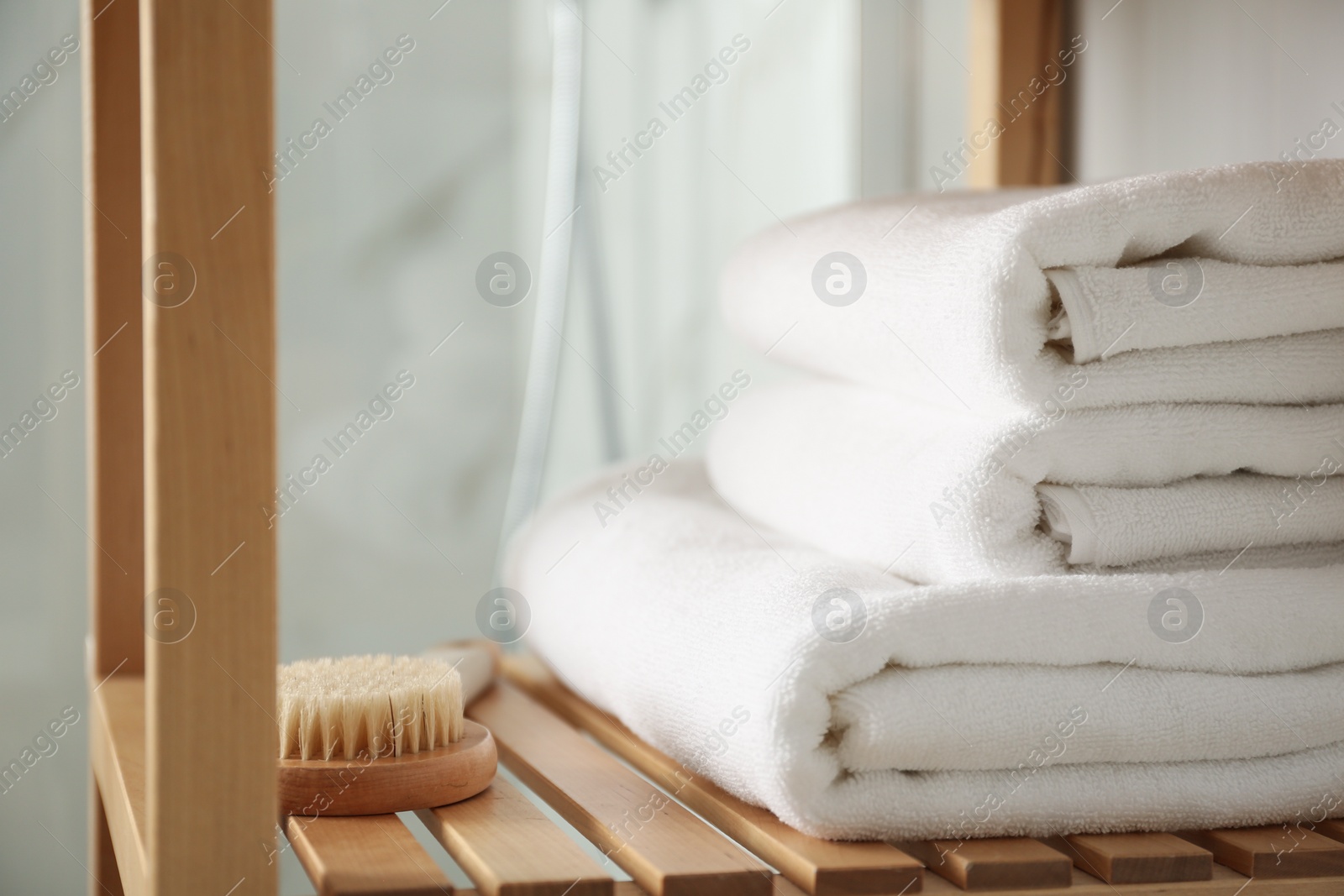 Photo of Shelving unit with clean towels in bathroom interior