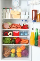 Open refrigerator with many different products, closeup