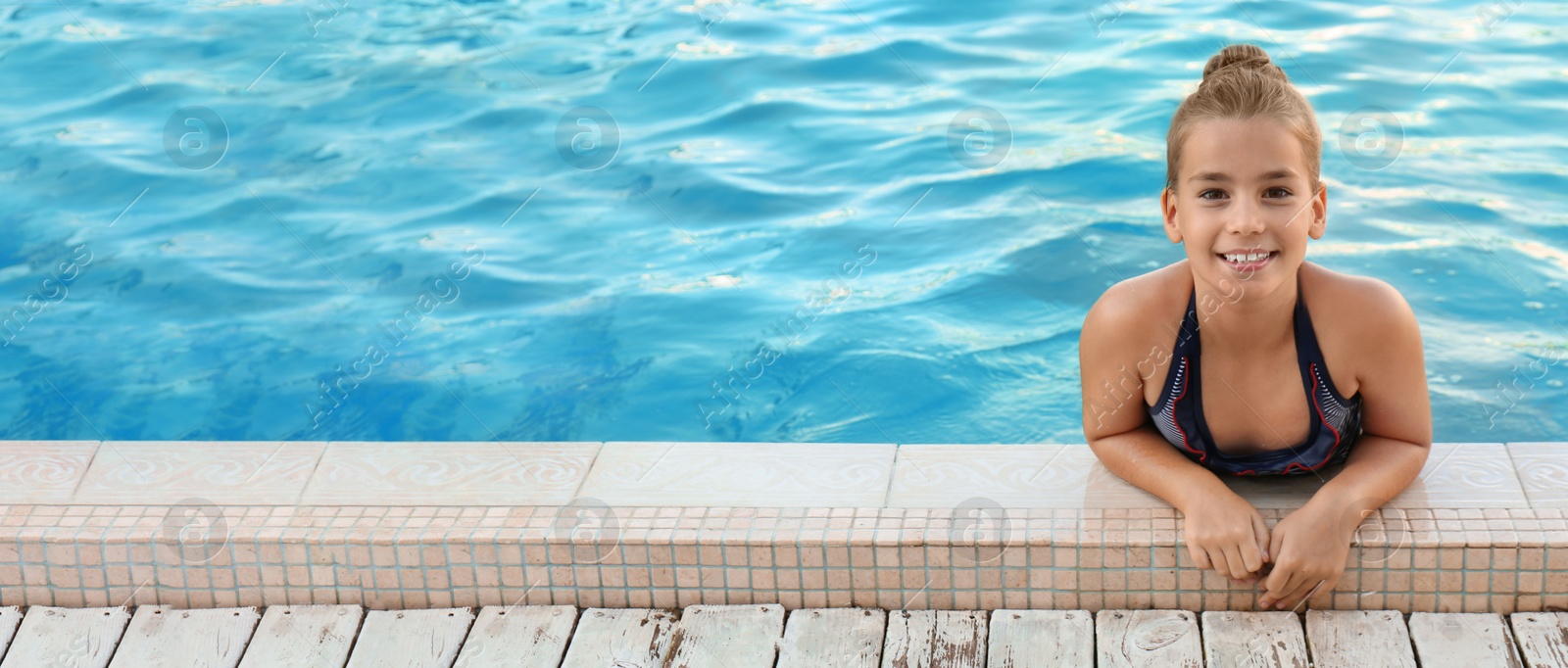 Image of Happy little girl in swimming pool on sunny day, space for text. Banner design