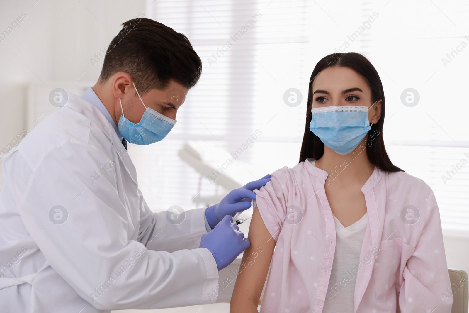 Photo of Doctor giving injection to patient in hospital. Vaccination campaign