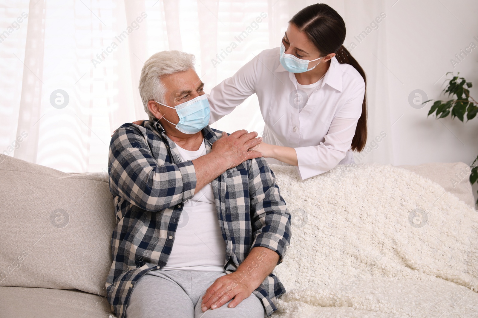 Photo of Doctor taking care of senior man with protective mask at nursing home