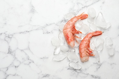 Photo of Fresh raw shrimps with ice on white background