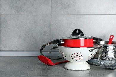 Photo of Set of different cooking utensils on grey countertop in kitchen. Space for text