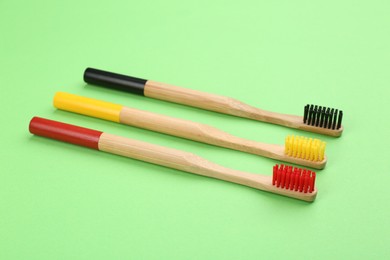 Natural bamboo toothbrushes with soft bristles on green background
