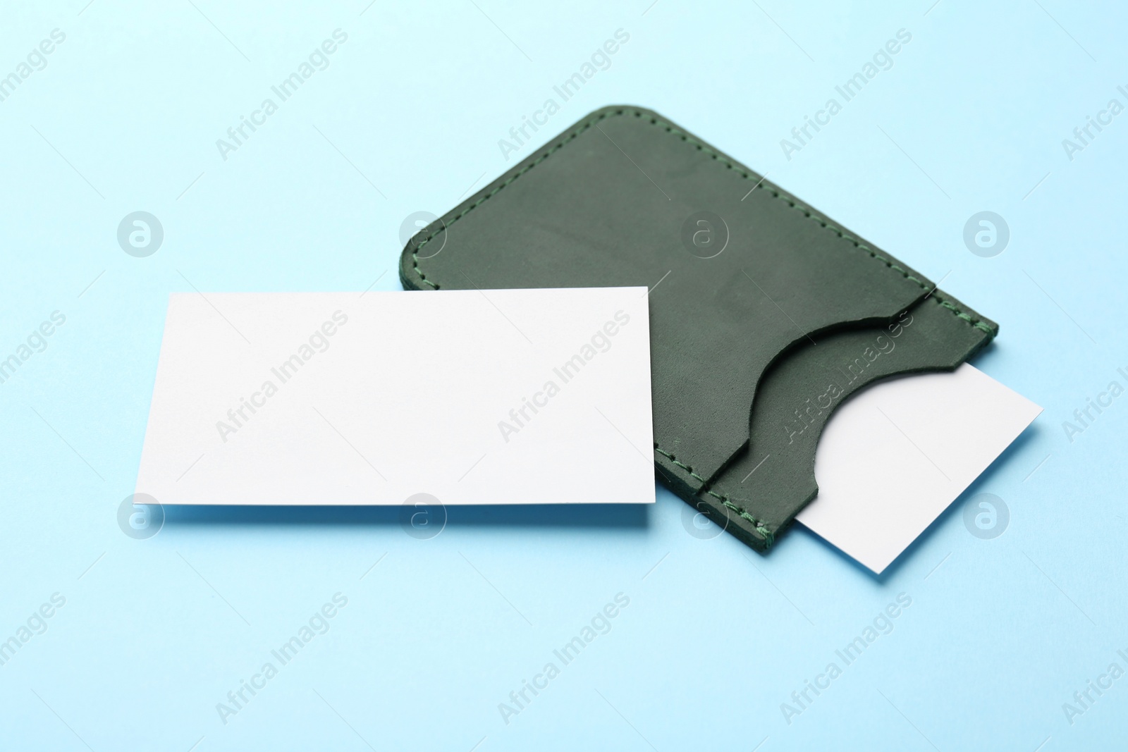 Photo of Leather business card holder with blank cards on light blue background