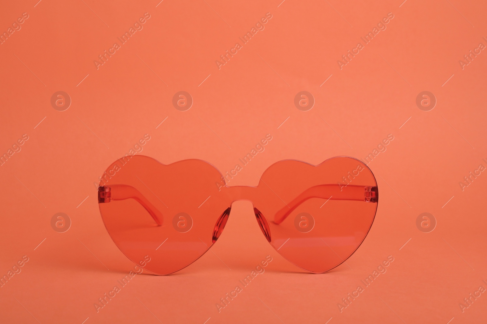 Photo of Heart shaped coral sunglasses on orange background