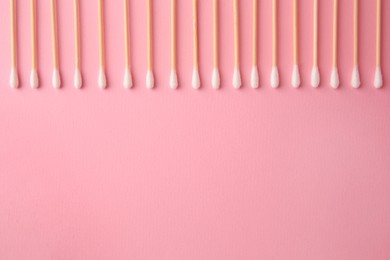 Photo of Many clean cotton buds on pink background, flat lay. Space for text