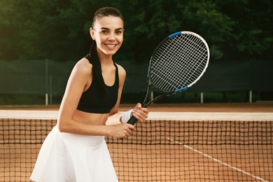 Photo of Young woman with tennis racket at court on sunny day