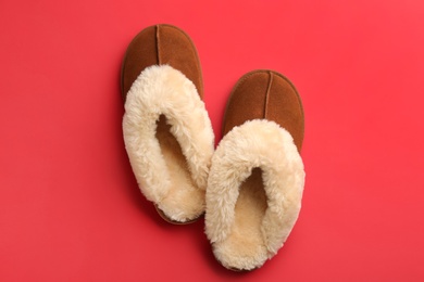 Photo of Pair of stylish soft slippers on red background, flat lay