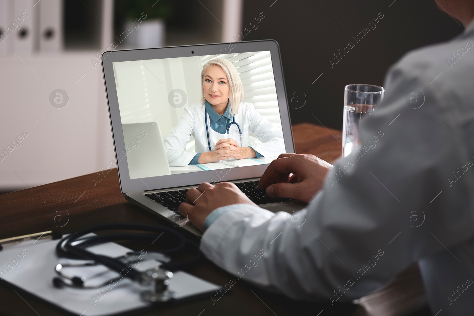 Image of Man using laptop for online consultation with mature female doctor, closeup 