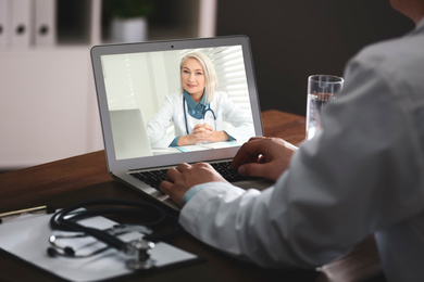 Man using laptop for online consultation with mature female doctor, closeup 