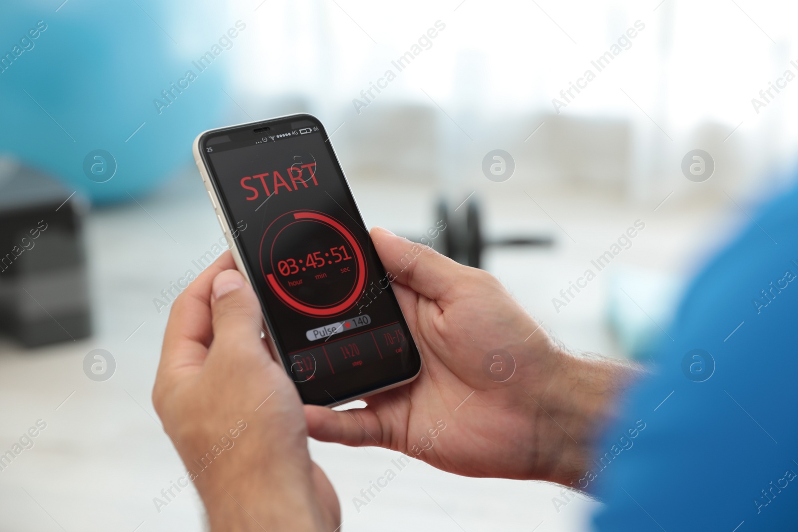 Photo of Man using fitness app on smartphone indoors, closeup