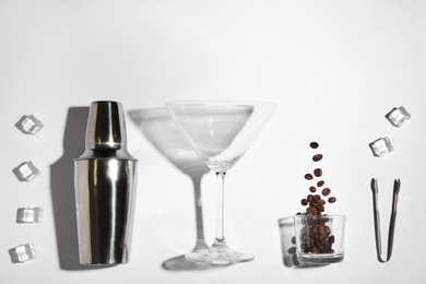 Photo of Flat lay composition with coffee beans, ice cubes and bar equipment on white background. Alcohol cocktail recipe - Espresso Martini