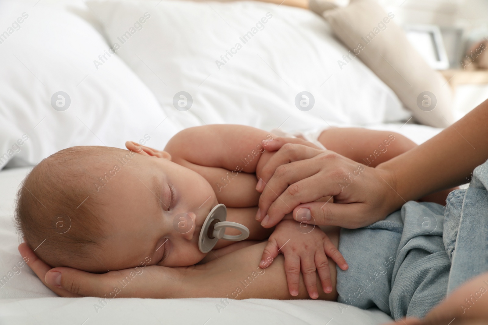 Photo of Mother with her cute baby sleeping in bed, closeup