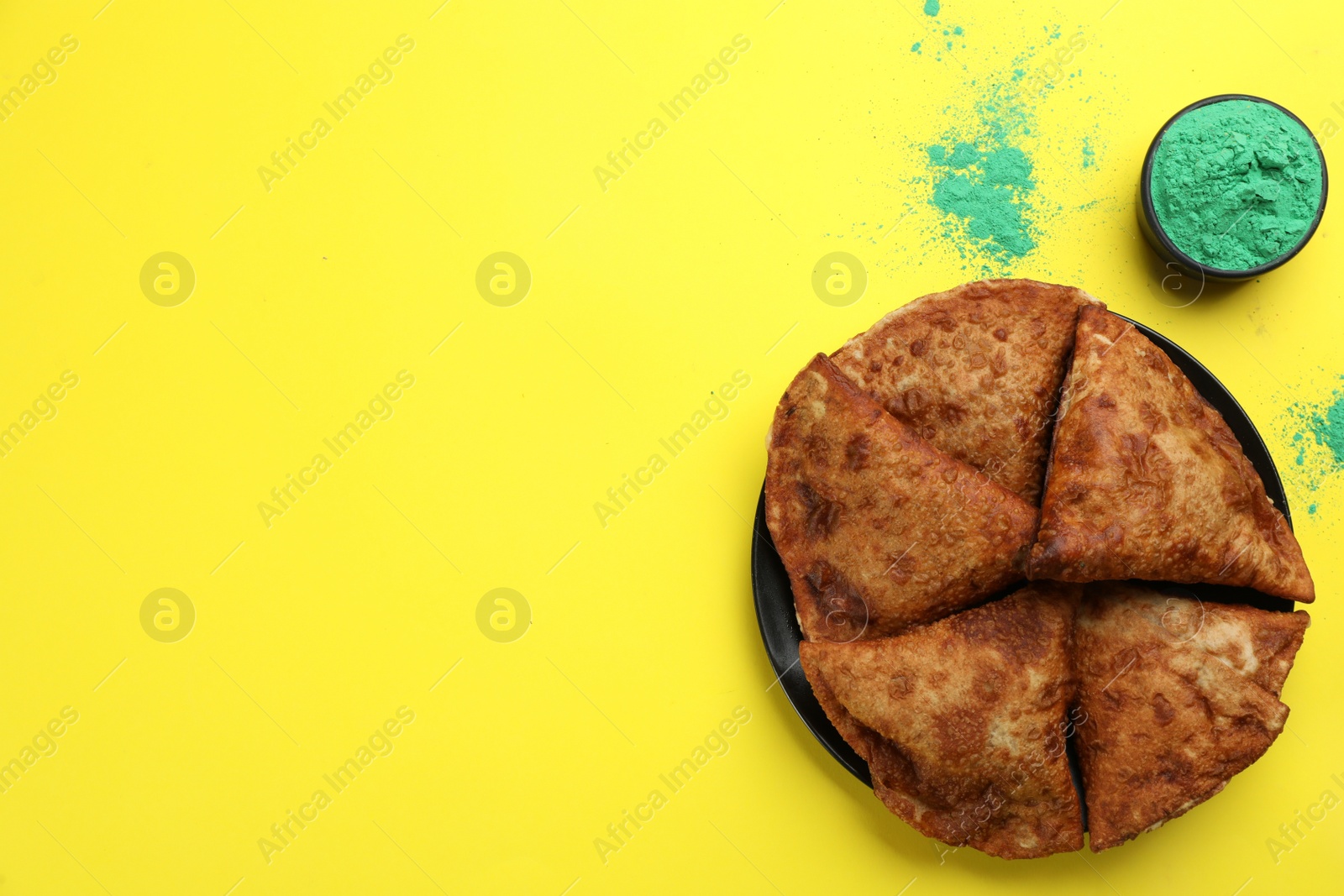 Photo of Traditional Indian food and color powder on yellow background, flat lay with space for text. Holi festival celebration