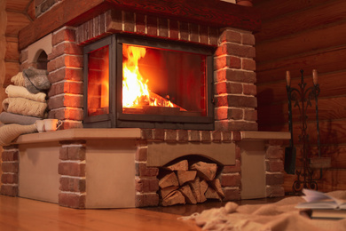 Fireplace with burning wood in room. Winter vacation