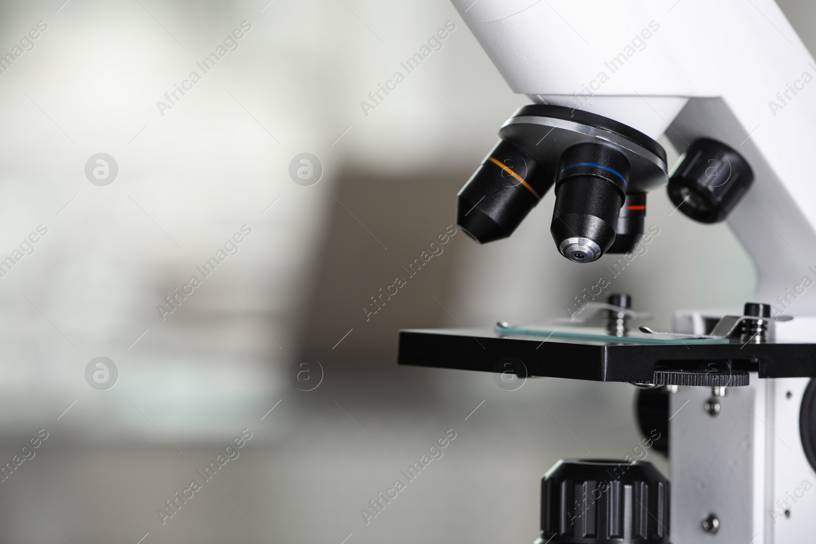 Photo of Modern medical microscope with glass slide on blurred background, closeup. Space for text