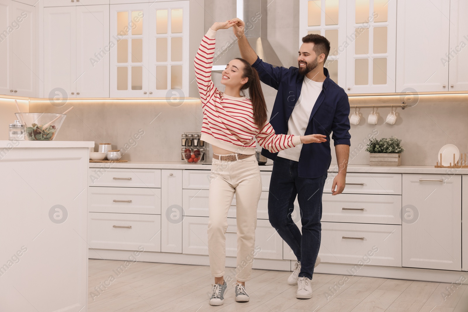 Photo of Happy lovely couple dancing together in kitchen