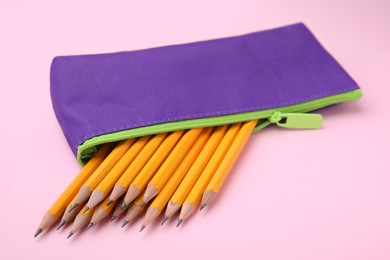 Photo of Many sharp pencils in pencil case on pink background