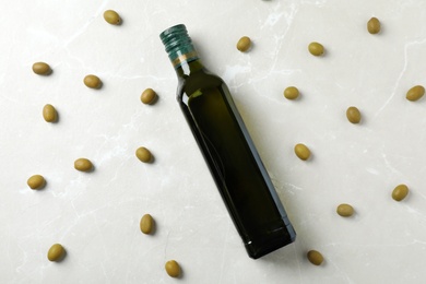 Flat lay composition with bottle of olive oil on light background