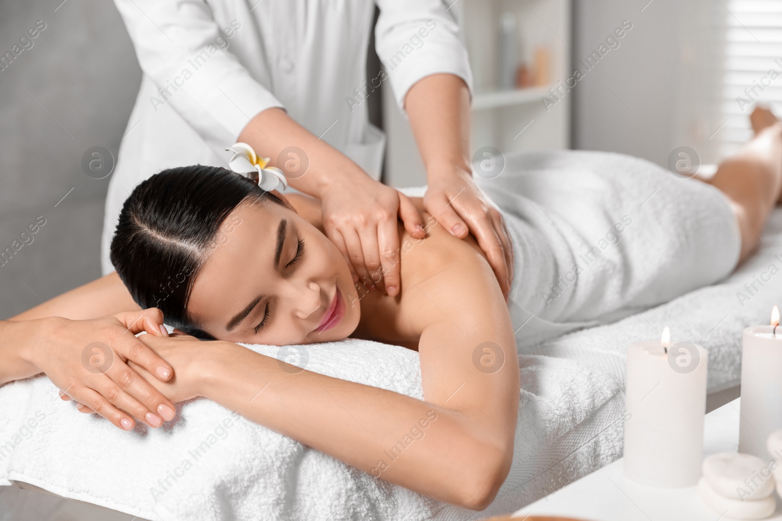 Photo of Beautiful woman receiving back massage in beauty salon, closeup