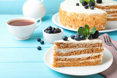 Photo of Delicious cake with blueberries on light blue wooden table