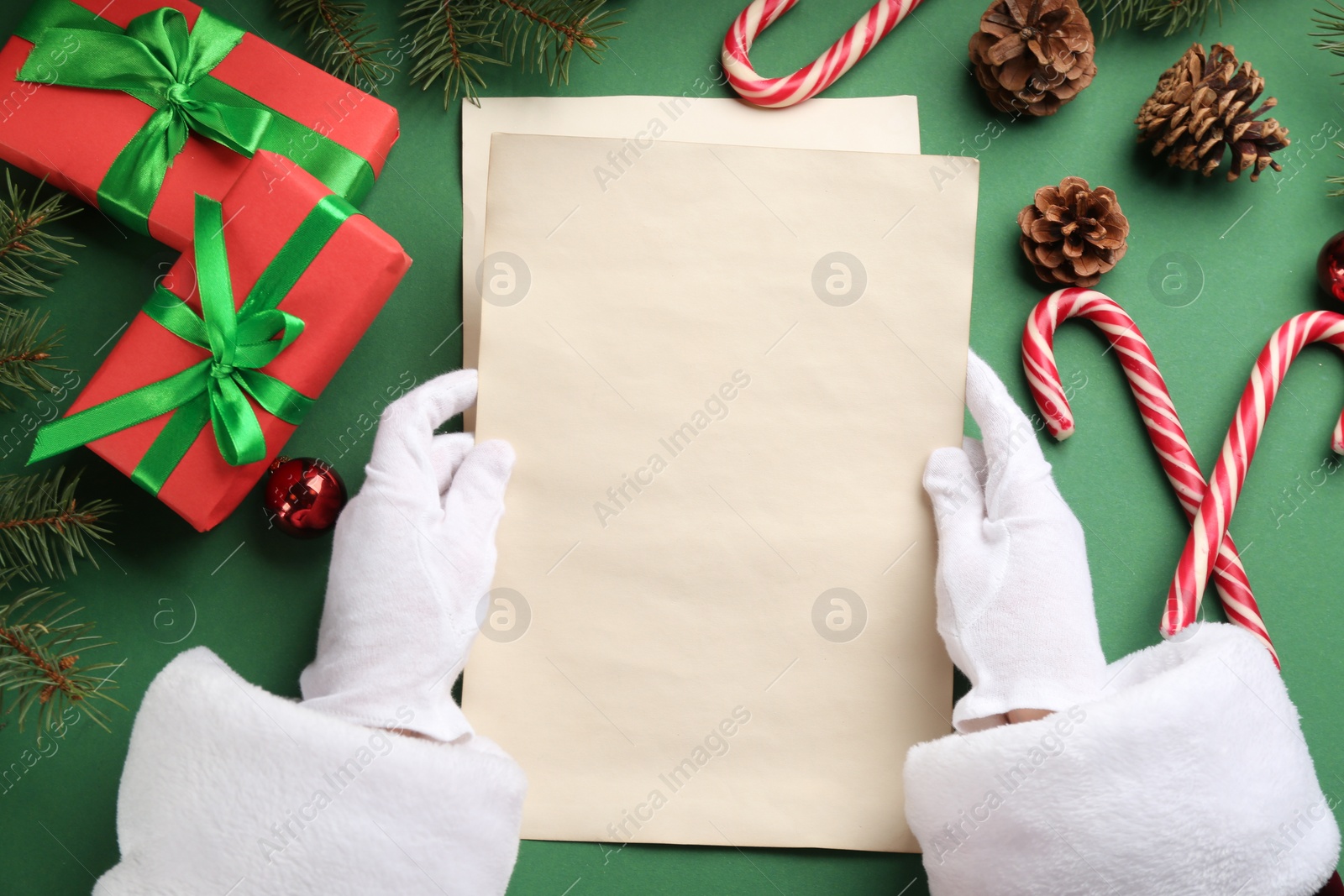 Photo of Santa holding letter at green table, top view