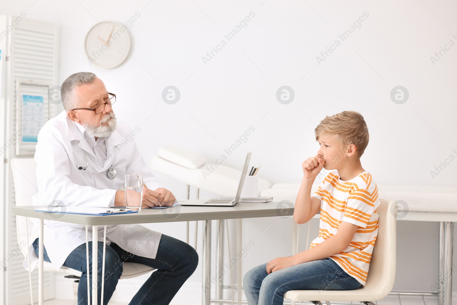 Photo of Coughing little boy visiting doctor at clinic