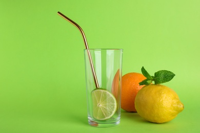 Photo of Composition with glass, citrus fruits and mint on color background, space for text. Summer cocktail recipe