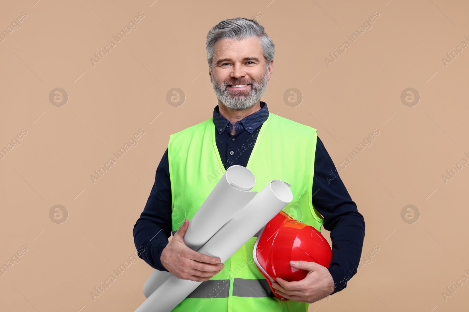 Photo of Architect with hard hat and drafts on beige background