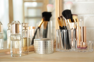 Perfumes and makeup products on dressing table