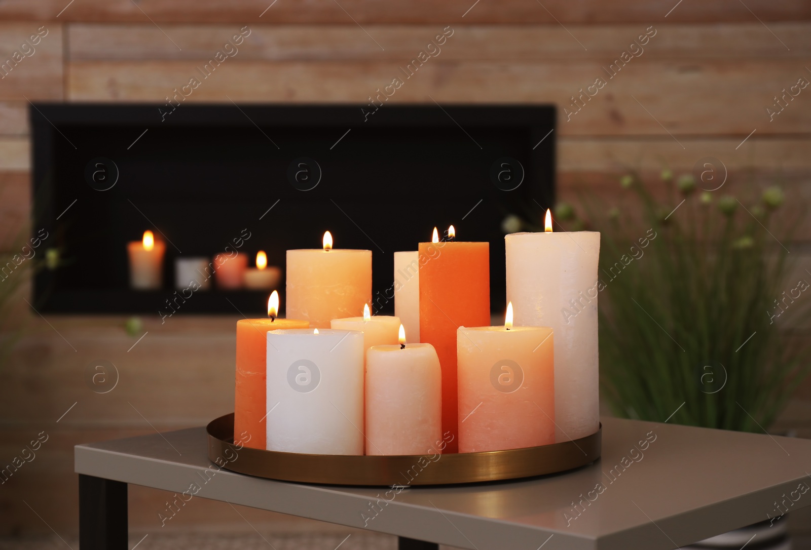 Photo of Tray with burning candles on table in living room