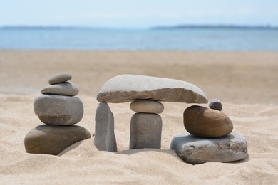 Photo of Stacks of stones on beautiful sandy beach near sea