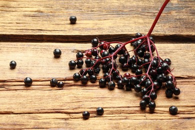 Photo of Black elderberries (Sambucus) on wooden table, above view