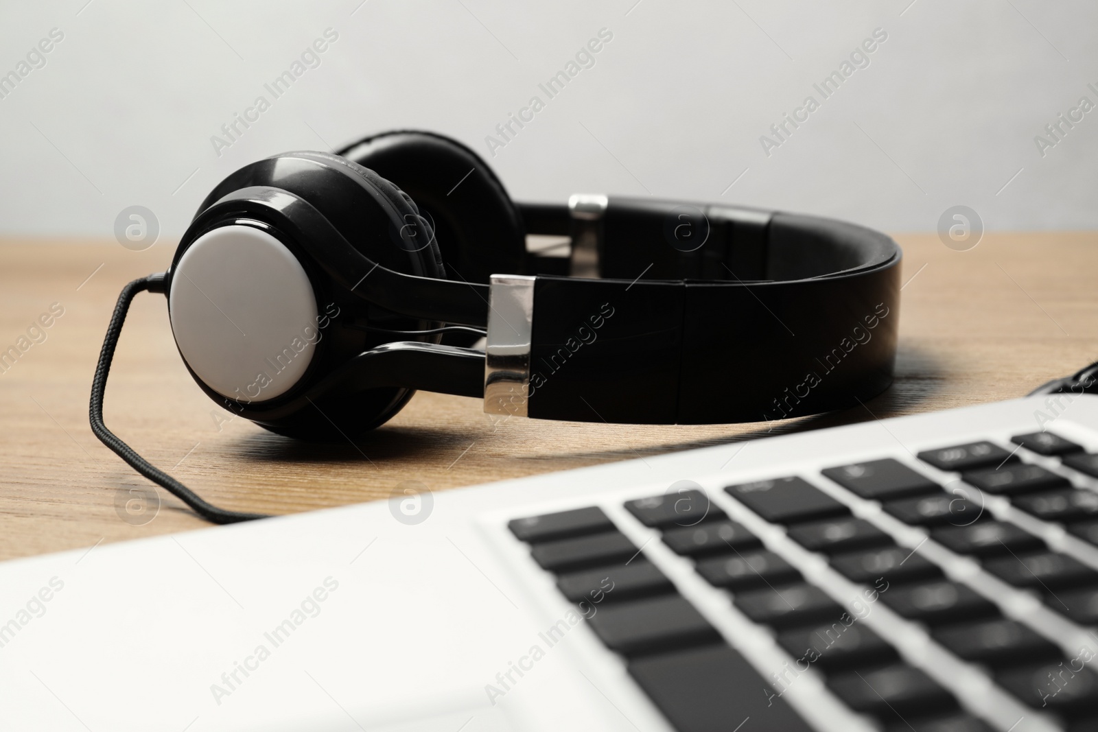 Photo of Stylish headphones and laptop on table. Modern technology